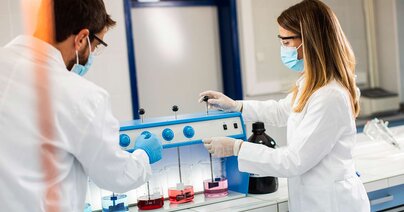 Gruppe junger Forscher analysiert chemische Daten im Flockungsgerät im Labor 
