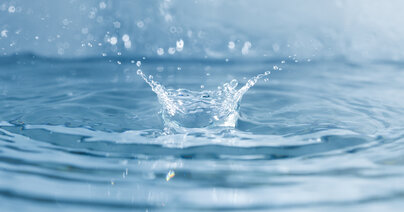 Wassertropfen trifft auf Wasseroberfläche