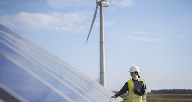 Frau mit Helm, Solaranlage, Windrad