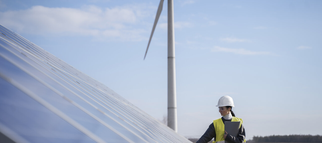 Frau mit Helm, Solaranlage, Windrad