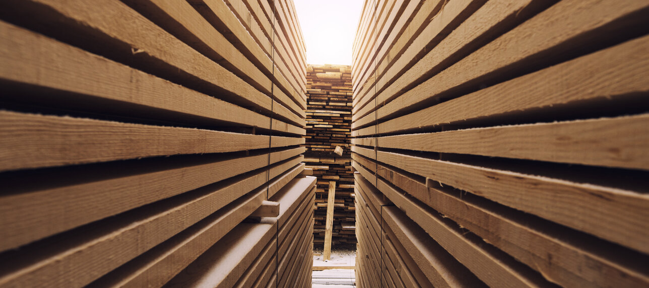 Gang zwischen Stapeln mit Holzbrettern