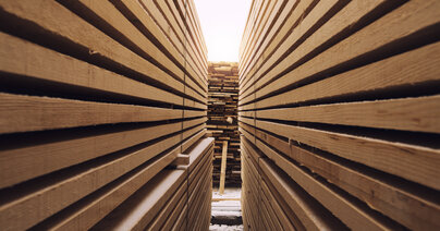 Przejście między stosami drewnianych desek