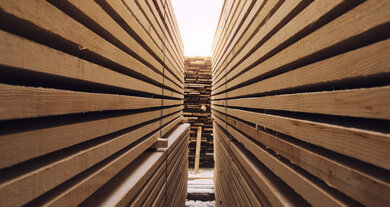 Gang zwischen Stapeln mit Holzbrettern